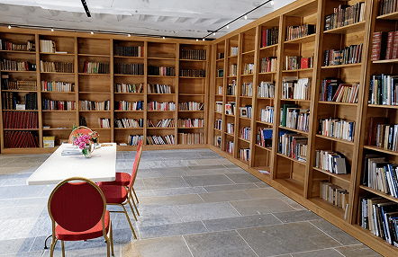 Salle de bibliothèque moderne avec étagères remplies de livres.
