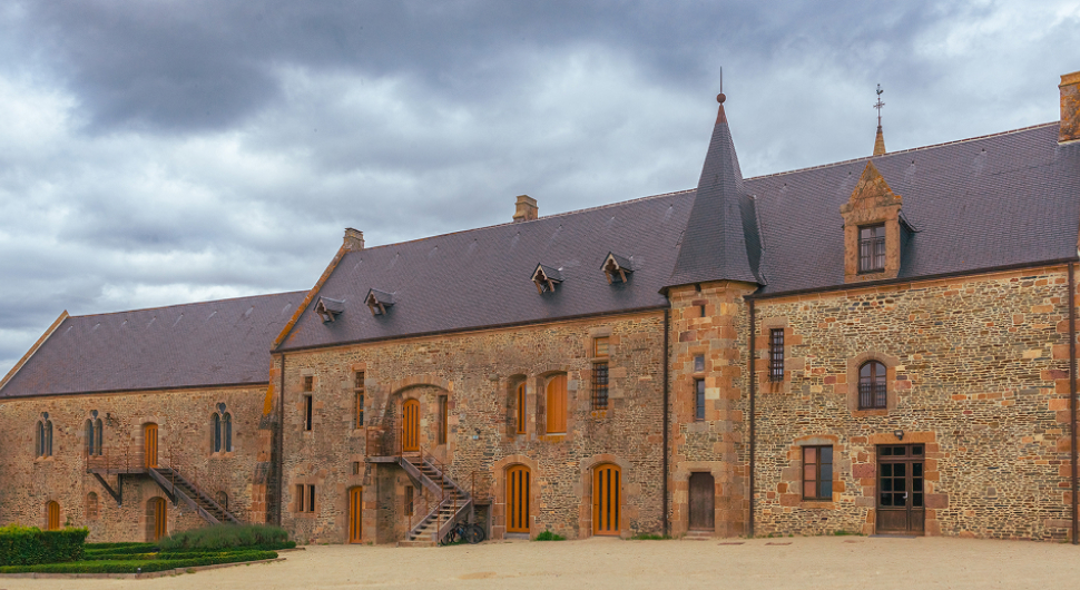 Abbaye médiévale avec cour et paysage champêtre