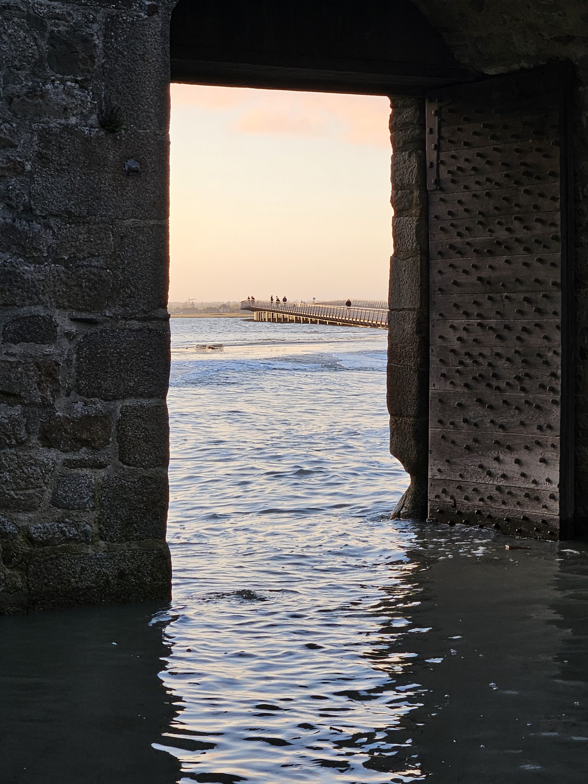 Vue sur la mer depuis une porte en pierre.