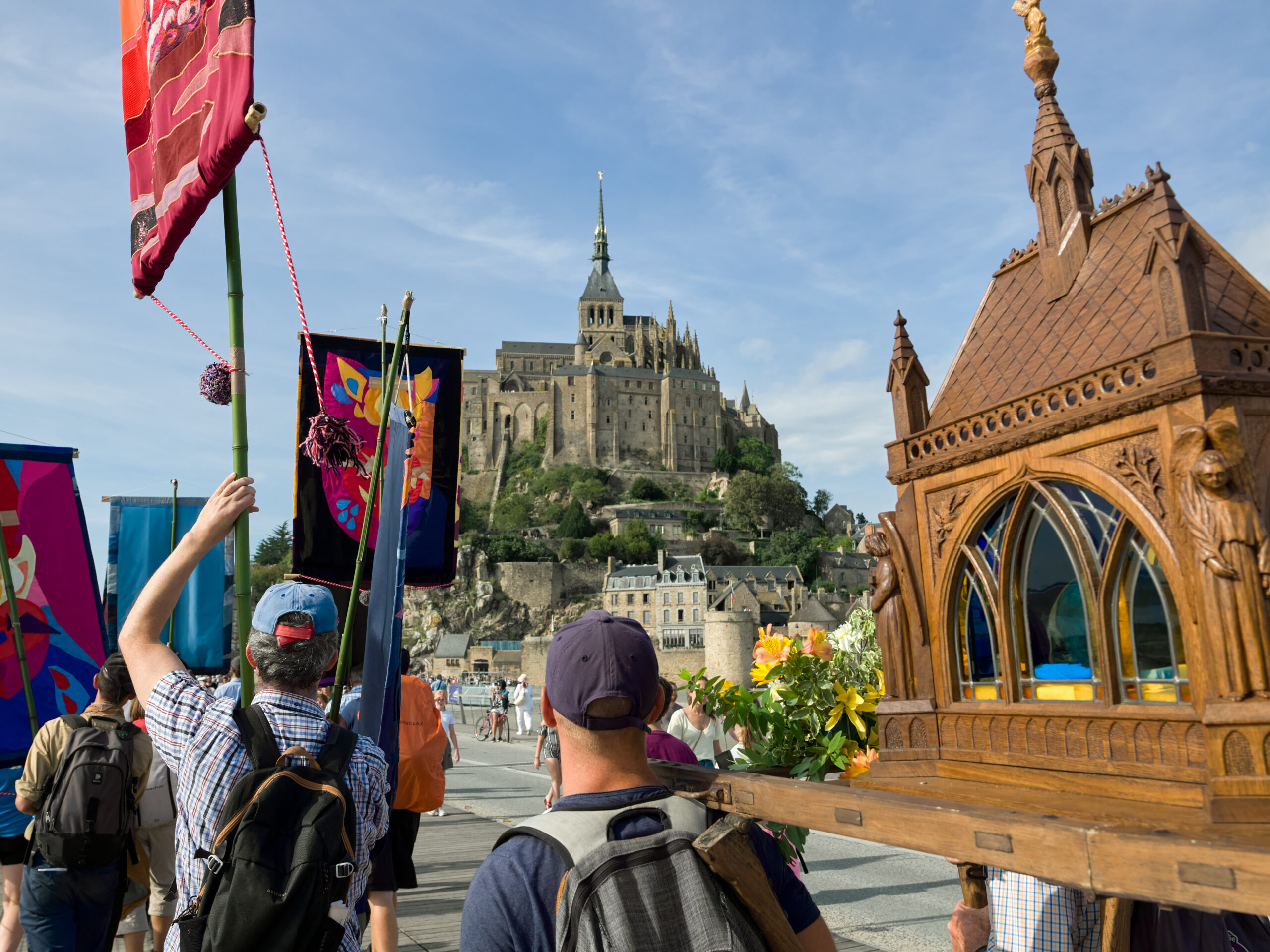 Procession vers le Mont-Saint-Michel en arrière-plan.