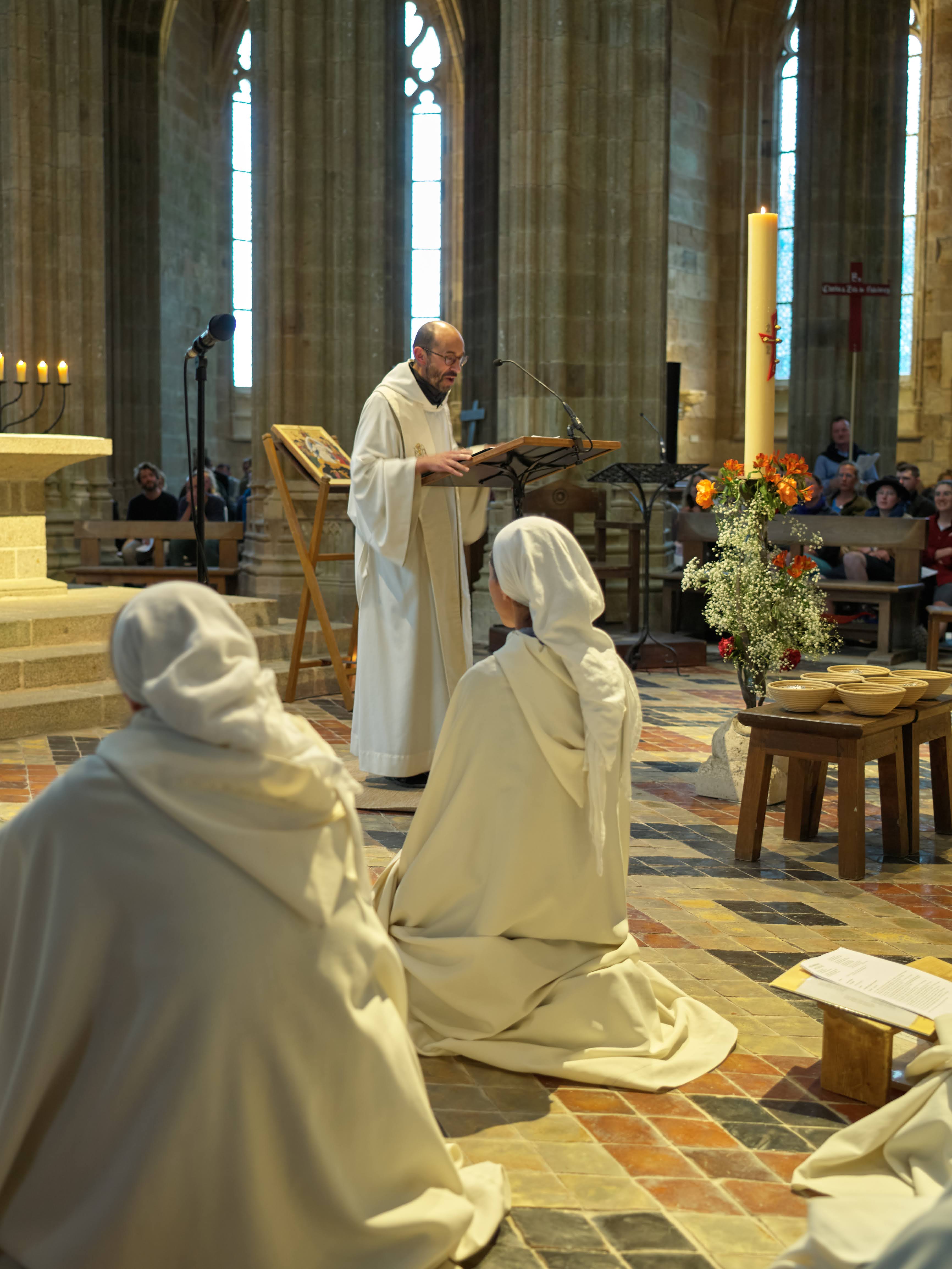 Cérémonie religieuse dans une église avec prêtre lisant.