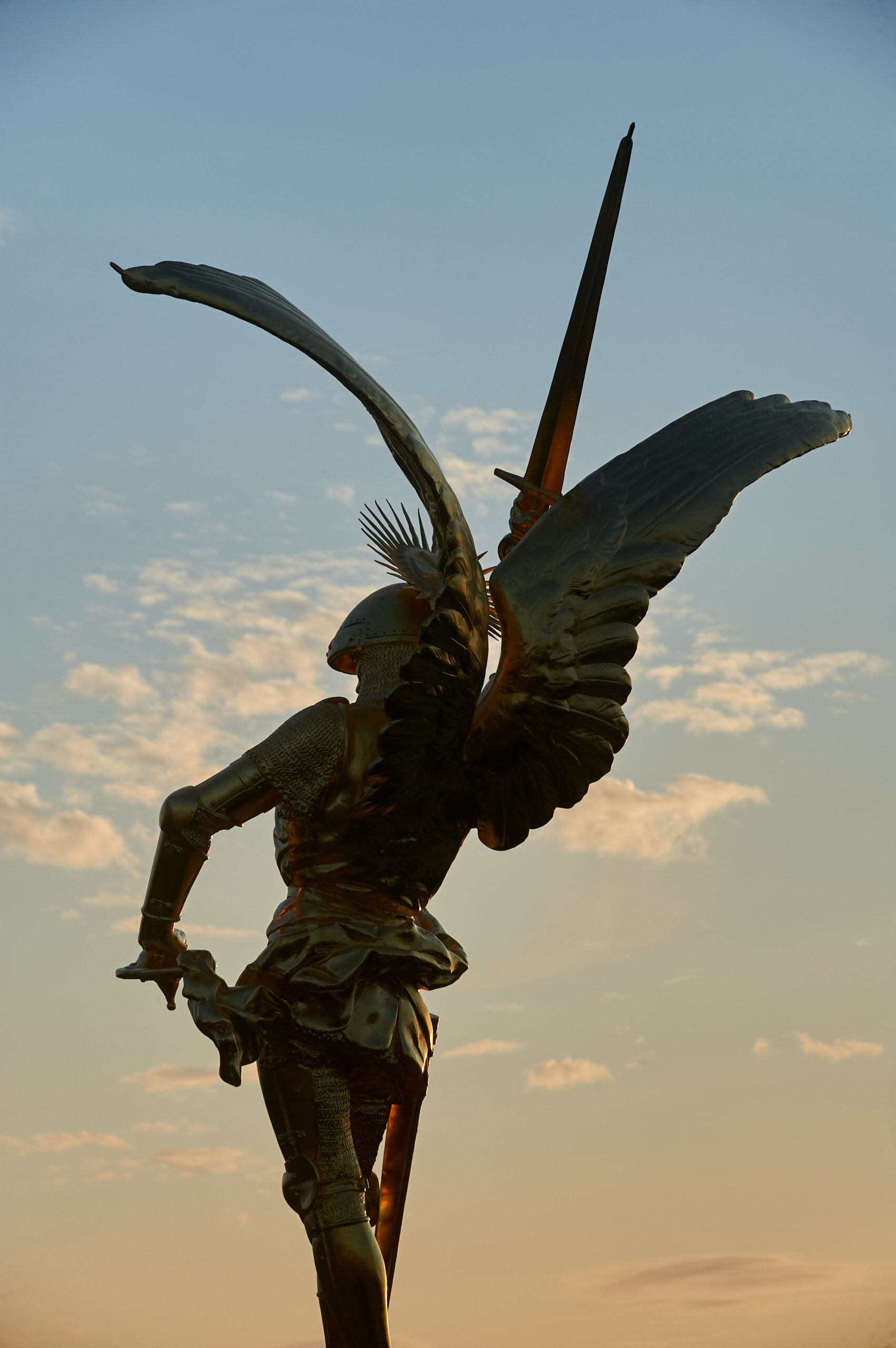 Statue ailée avec épée au crépuscule.