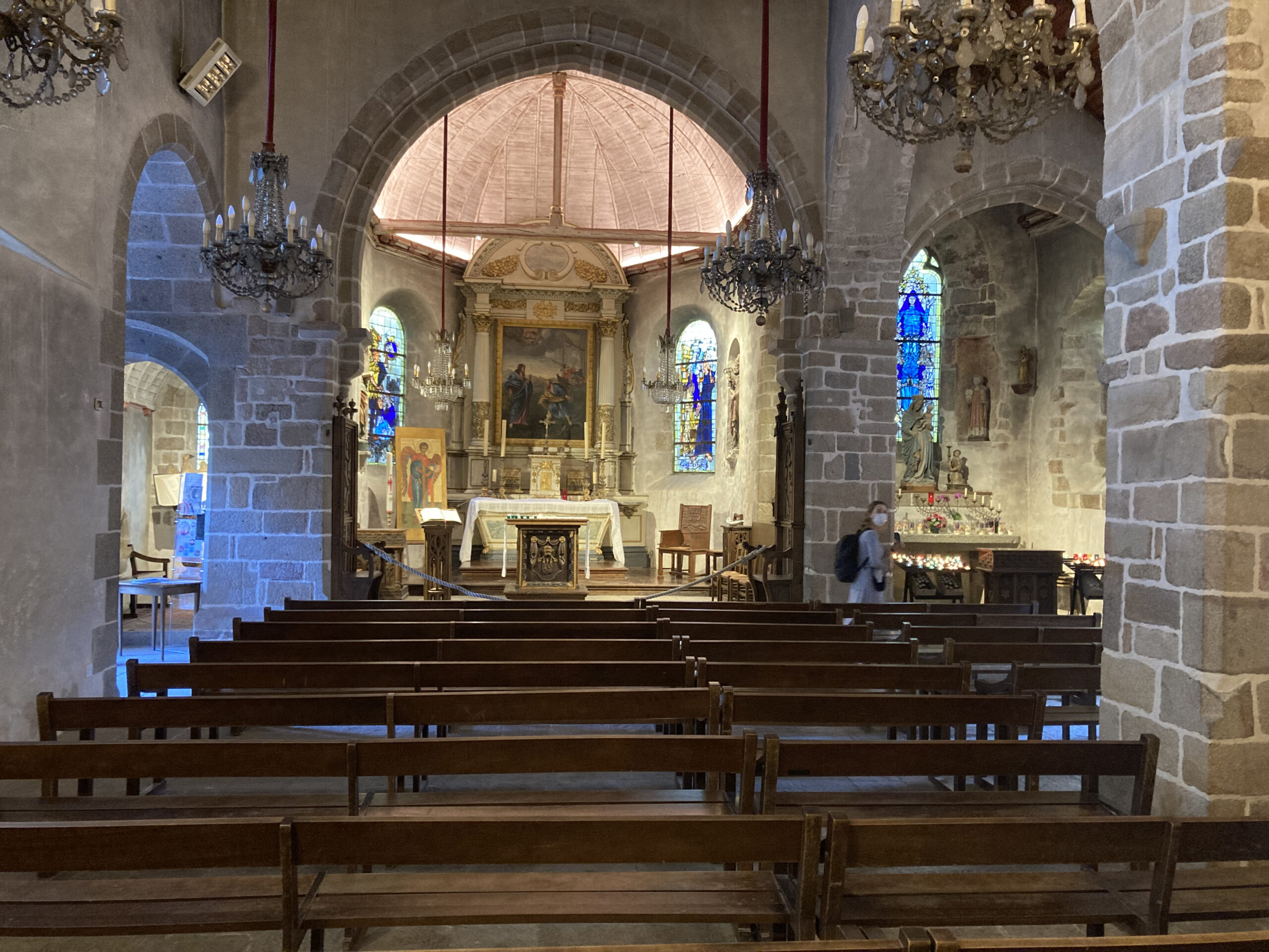 Intérieur d'une église avec autel et vitraux colorés.