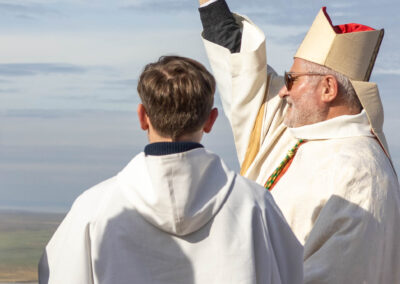 Cérémonie religieuse en plein air avec deux prêtres.